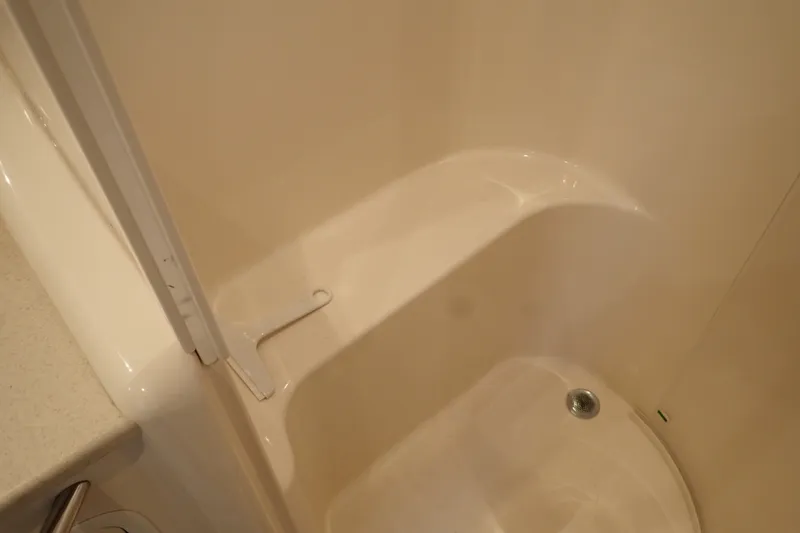 Slide: The Image of Shower area in 1998 Sea Ray 480 Sedan Bridge yacht, featuring a clean, white interior. - 188