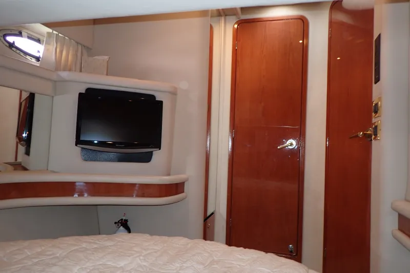 Slide: The Image of Interior of 1998 Sea Ray 480 Sedan Bridge with TV and wooden doors. - 26