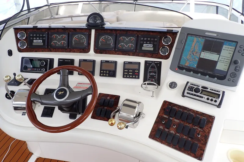 Slide: The Image of 1998 Sea Ray 480 Sedan Bridge helm with navigation instruments and steering wheel. - 42
