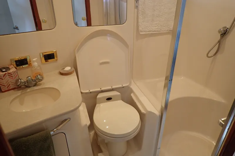 Slide: The Image of Bathroom interior of 1998 Sea Ray 480 Sedan Bridge yacht, featuring toilet and shower. - 28