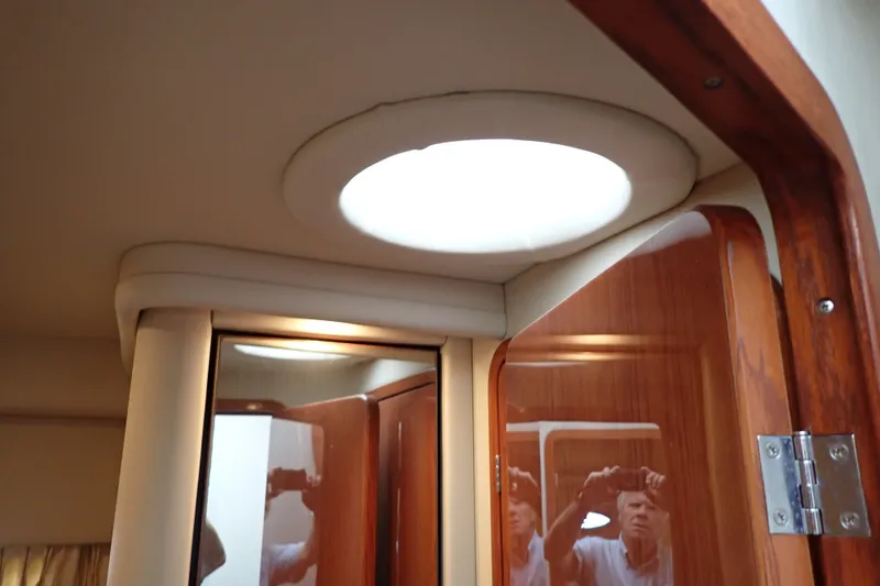 Slide: The Image of Interior of 1998 Sea Ray 480 Sedan Bridge with wooden door and ceiling light. - 140