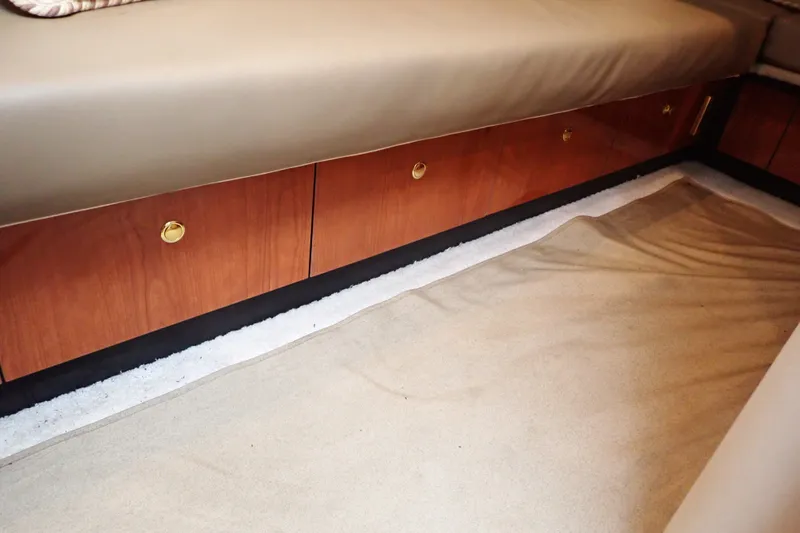 Slide: The Image of Interior view of 1998 Sea Ray 480 Sedan Bridge with wooden cabinetry and beige carpet. - 148