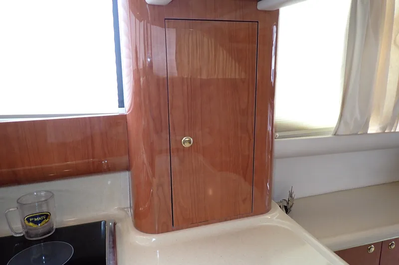 Slide: The Image of Interior of 1998 Sea Ray 480 Sedan Bridge with polished wood cabinetry and countertop. - 118