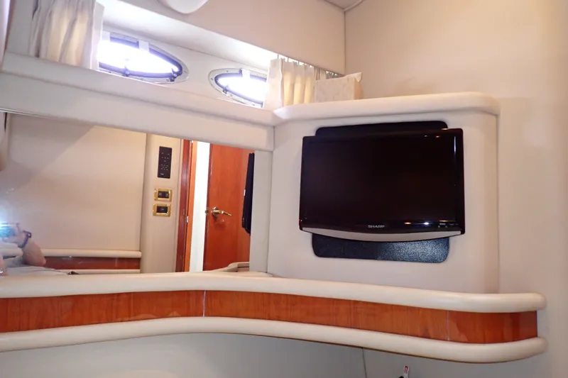 Slide: The Image of Interior of 1998 Sea Ray 480 Sedan Bridge with mounted TV and porthole windows. - 139