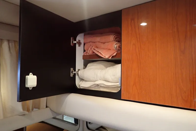 Slide: The Image of Open cabinet with towels inside on a 1998 Sea Ray 480 Sedan Bridge yacht. - 147