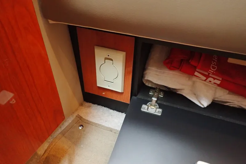 Slide: The Image of 1998 Sea Ray 480 Sedan Bridge interior with storage compartment and electrical outlet. - 150