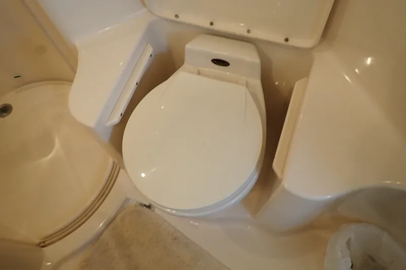 Slide: The Image of Bathroom interior of 1998 Sea Ray 480 Sedan Bridge yacht, featuring a compact toilet. - 39