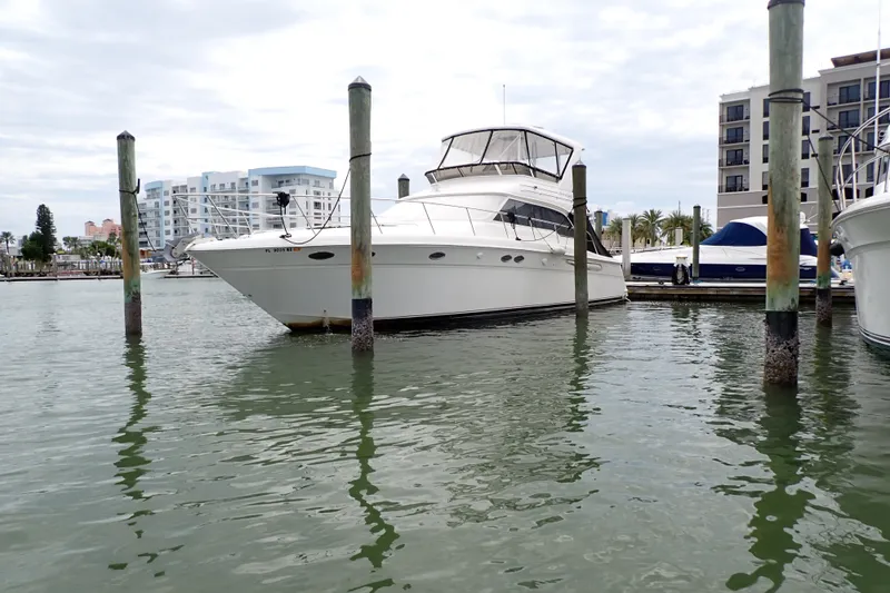 Slide: The Image of 1998 Sea Ray 480 Sedan Bridge yacht docked in marina, surrounded by water and buildings. - 93