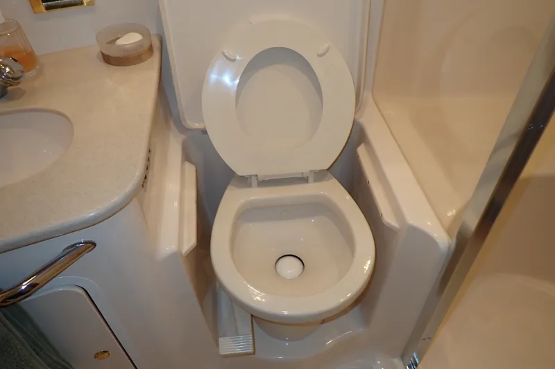 Slide: The Image of Bathroom interior of 1998 Sea Ray 480 Sedan Bridge yacht, featuring toilet and sink. - 159
