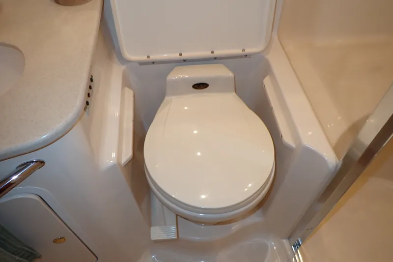 Slide: The Image of 1998 Sea Ray 480 Sedan Bridge bathroom with compact toilet and sink. - 158