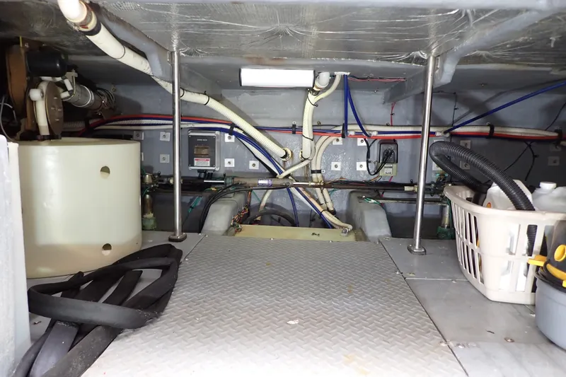 Slide: The Image of Engine room of 1998 Sea Ray 480 Sedan Bridge with visible pipes and equipment. - 205