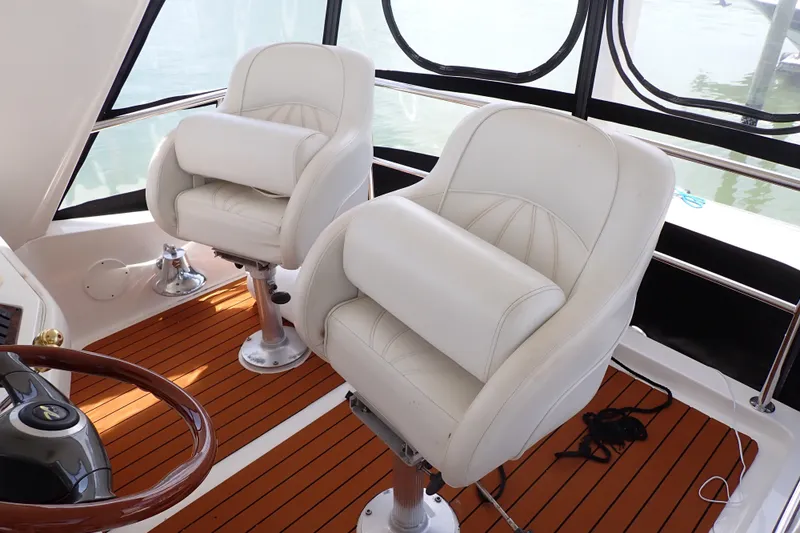 Slide: The Image of White captain chairs on 1998 Sea Ray 480 Sedan Bridge yacht with wooden deck. - 8