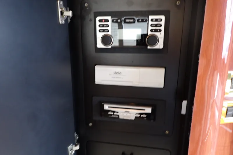 Slide: The Image of Control panel inside 1998 Sea Ray 480 Sedan Bridge yacht, featuring audio and electronic systems. - 129