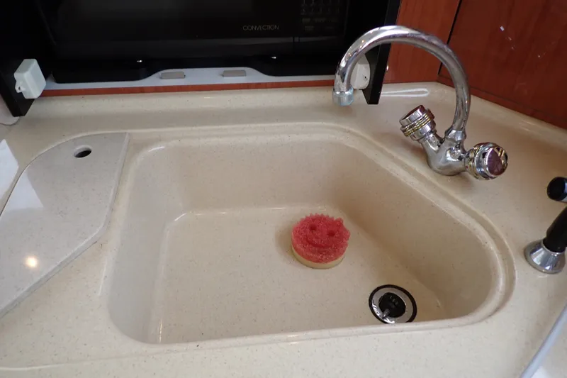 Slide: The Image of Kitchen sink with faucet and sponge on Sea Ray 480 Sedan Bridge, 1998 model. - 104