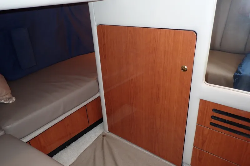 Slide: The Image of Interior cabin of 1998 Sea Ray 480 Sedan Bridge with wood paneling and bedding. - 23