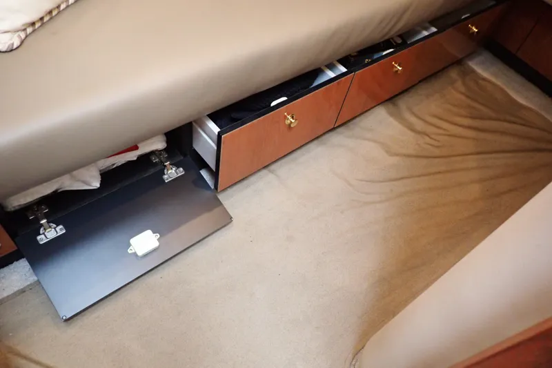 Slide: The Image of Interior storage of 1998 Sea Ray 480 Sedan Bridge with open drawers and beige carpet. - 149