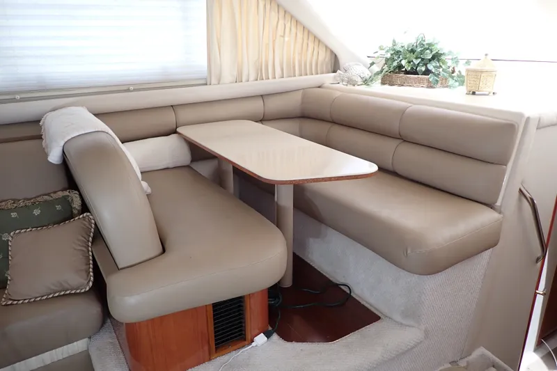Slide: The Image of Luxurious interior of 1998 Sea Ray 480 Sedan Bridge with beige seating and dining area. - 17