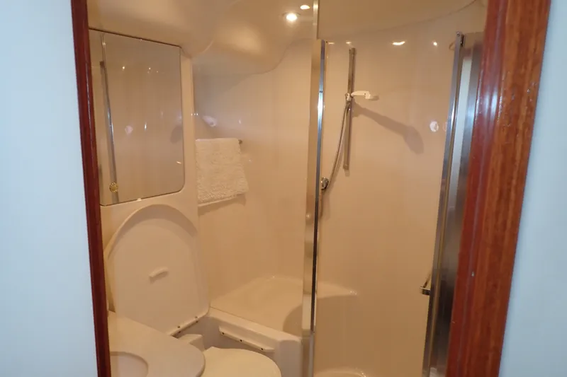 Slide: The Image of Bathroom interior of 1998 Sea Ray 480 Sedan Bridge yacht, featuring shower and toilet. - 27