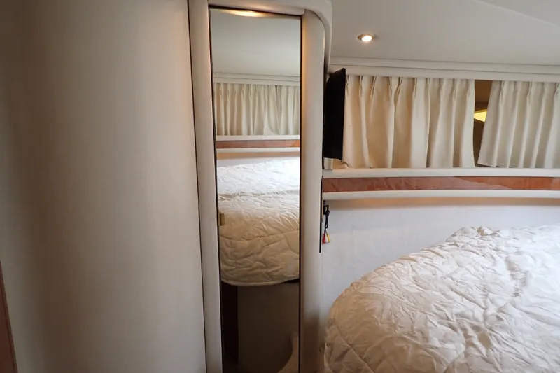 Slide: The Image of Interior cabin of 1998 Sea Ray 480 Sedan Bridge with bed and curtains. - 167