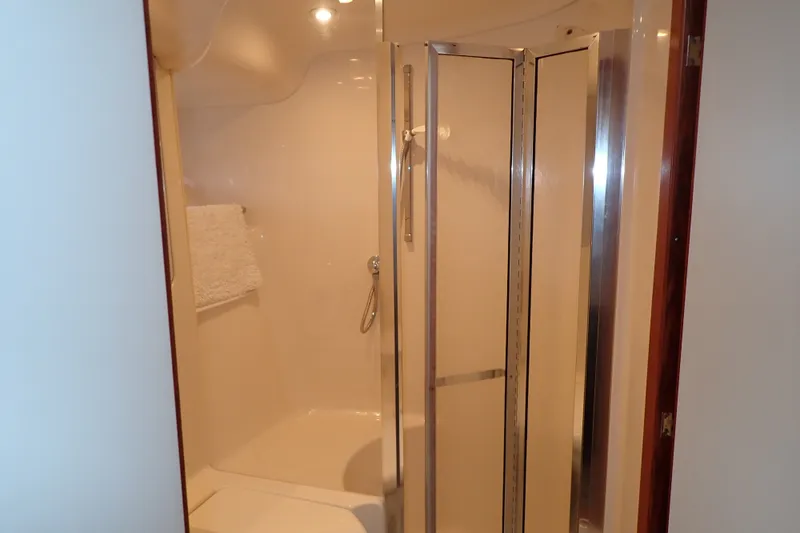 Slide: The Image of Shower area in 1998 Sea Ray 480 Sedan Bridge yacht, featuring glass door and towel rack. - 164
