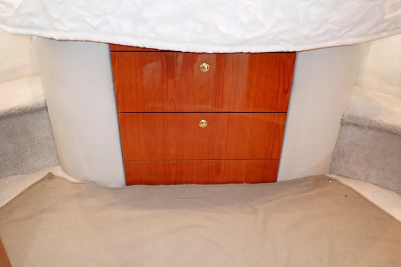 Slide: The Image of Interior of 1998 Sea Ray 480 Sedan Bridge with wooden drawers and carpeted flooring. - 172