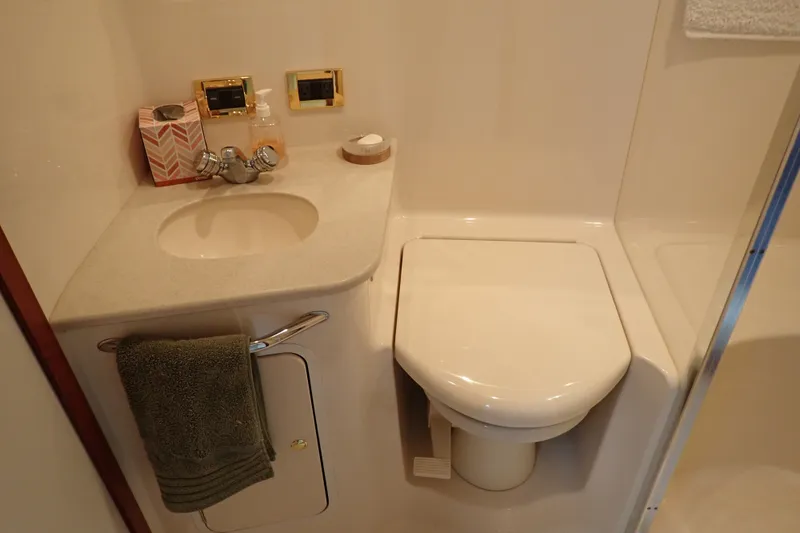 Slide: The Image of Bathroom interior of 1998 Sea Ray 480 Sedan Bridge yacht, featuring sink and toilet. - 31
