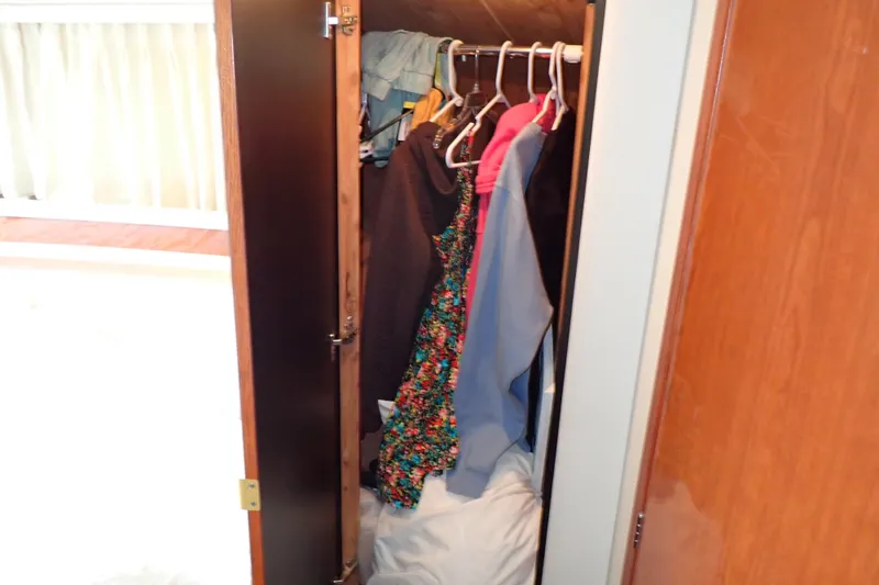 Slide: The Image of Closet with clothes inside a 1998 Sea Ray 480 Sedan Bridge yacht. - 171