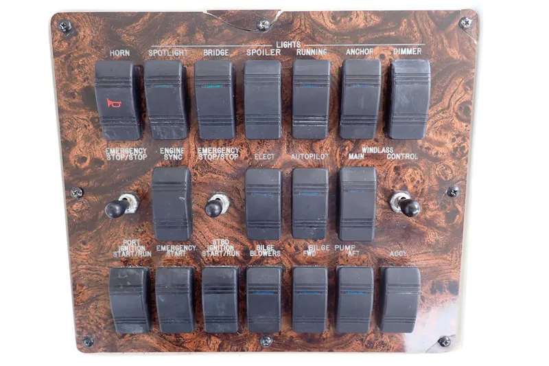 Slide: The Image of Control panel of a 1998 Sea Ray 480 Sedan Bridge with various switches and toggles. - 50