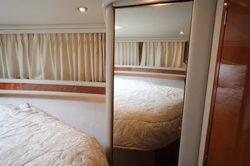 Slide: The Image of Interior cabin of 1998 Sea Ray 480 Sedan Bridge with bed and curtains. - 170