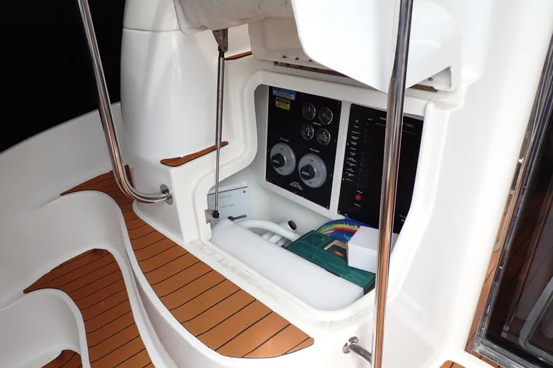 Slide: The Image of 1998 Sea Ray 480 Sedan Bridge control panel with teak flooring and stainless steel railings. - 72