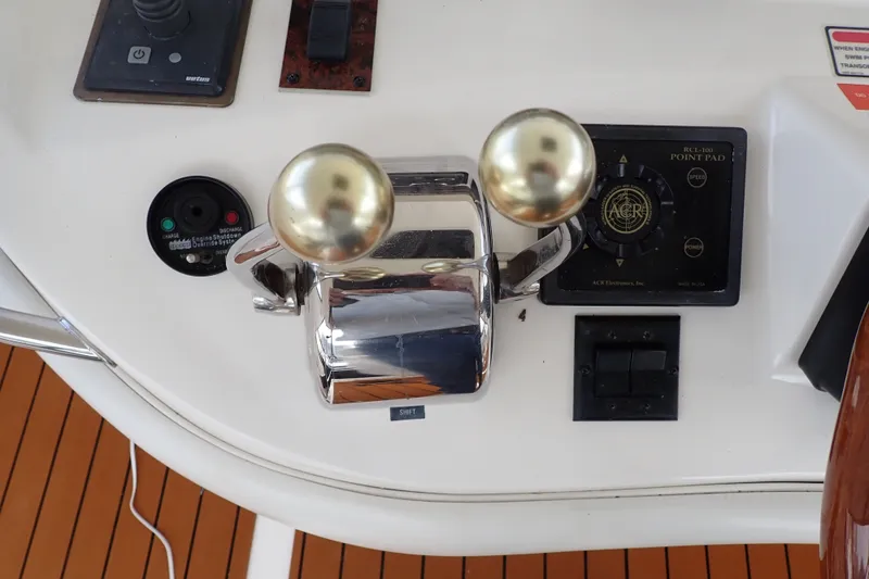 Slide: The Image of 1998 Sea Ray 480 Sedan Bridge helm controls with dual throttle levers and navigation panel. - 52