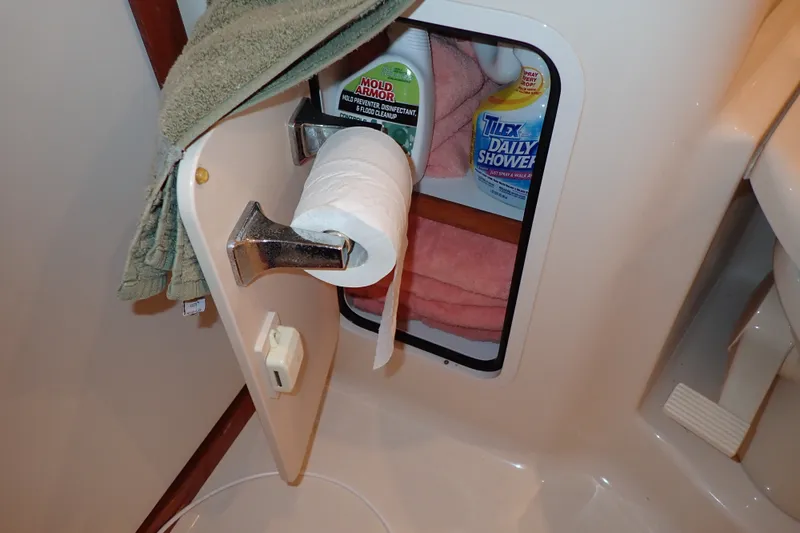 Slide: The Image of 1998 Sea Ray 480 Sedan Bridge bathroom storage with cleaning supplies and toilet paper. - 161