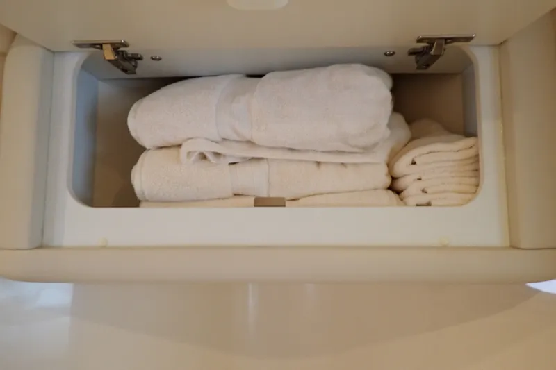 Slide: The Image of White towels neatly stored in a cabinet on a 1998 Sea Ray 480 Sedan Bridge. - 180