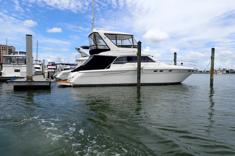 Slide: The Image of 1998 Sea Ray 480 Sedan Bridge yacht docked in a marina under a blue sky. - 91