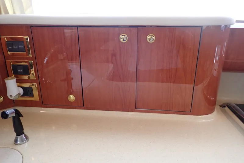 Slide: The Image of 1998 Sea Ray 480 Sedan Bridge interior with polished wood cabinetry and modern fixtures. - 112