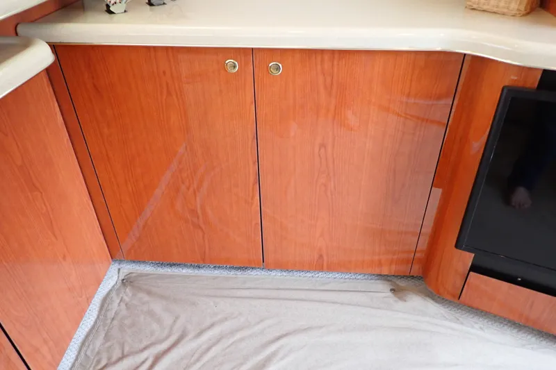 Slide: The Image of 1998 Sea Ray 480 Sedan Bridge interior with polished wood cabinetry and countertop. - 124