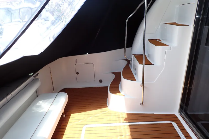 Slide: The Image of 1998 Sea Ray 480 Sedan Bridge interior with wooden flooring and curved staircase. - 12