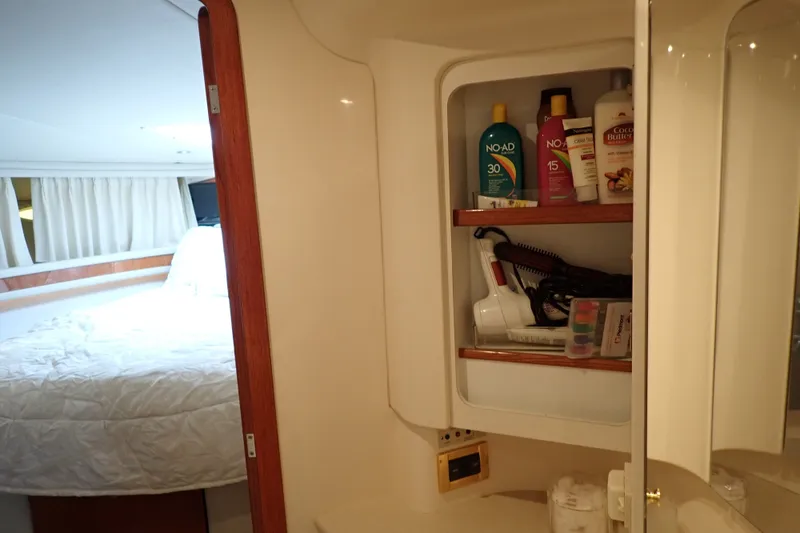 Slide: The Image of Cabin interior of 1998 Sea Ray 480 Sedan Bridge with open bathroom cabinet. - 177