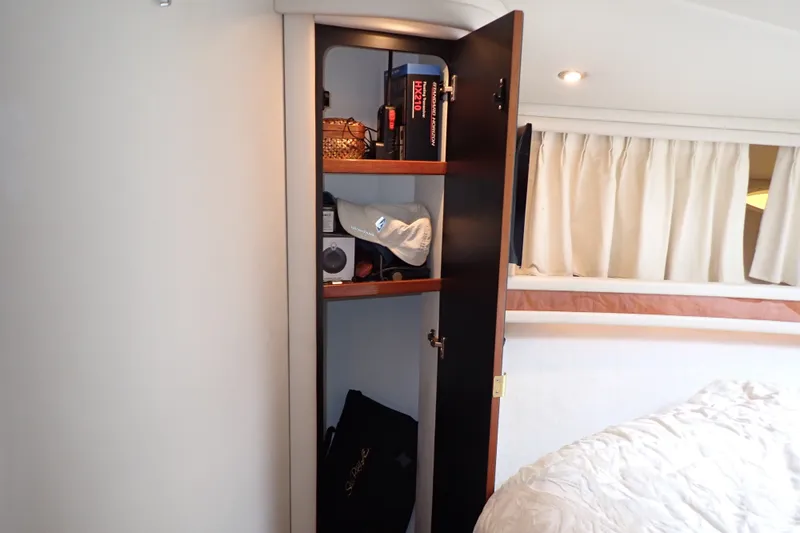 Slide: The Image of Cabinet interior on 1998 Sea Ray 480 Sedan Bridge yacht, showing shelves with various items. - 168