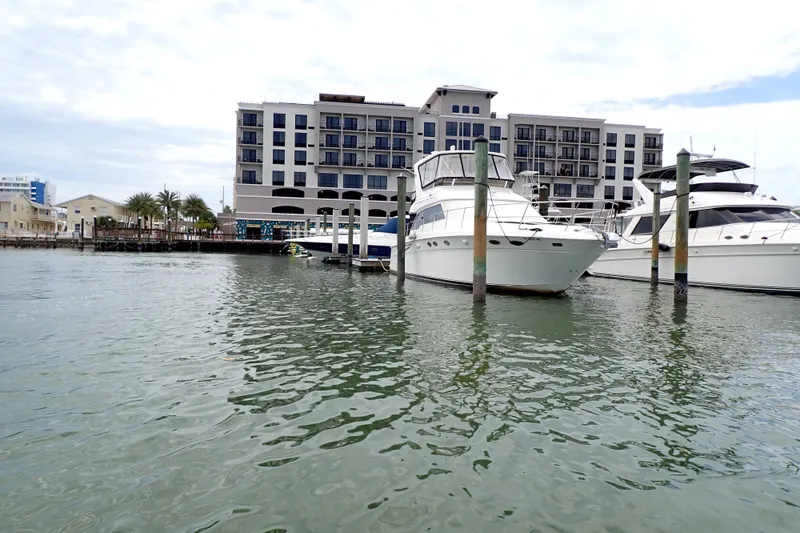 Slide: The Image of 1998 Sea Ray 480 Sedan Bridge yacht docked at marina with waterfront building backdrop. - 92