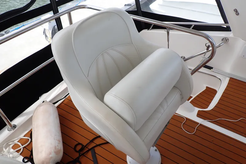 Slide: The Image of Captain's chair on 1998 Sea Ray 480 Sedan Bridge yacht with teak flooring. - 55