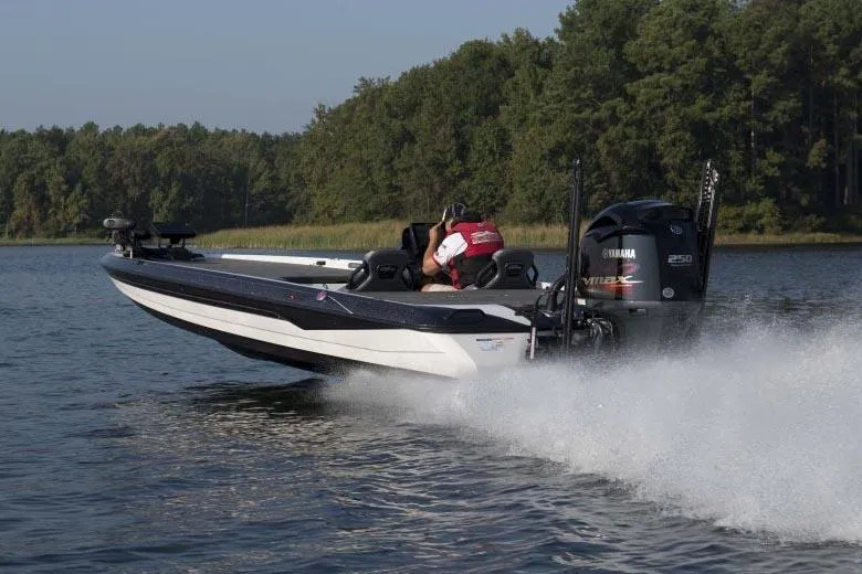 Slide: The Image of Manufacturer Provided Image: 2022 Skeeter FXR 21 boat speeding on a lake with forested shoreline. - 15
