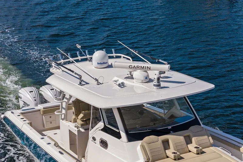 Slide: The Image of 2020 Pursuit S 408 Sport boat cruising on water with advanced navigation equipment. - 5