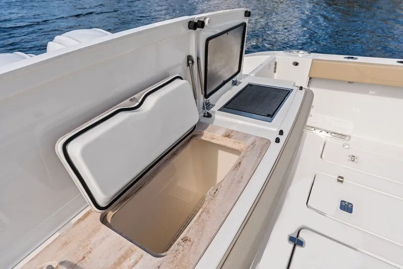 Slide: The Image of 2020 Pursuit S 408 Sport boat with open storage compartment and grill on deck. - 19