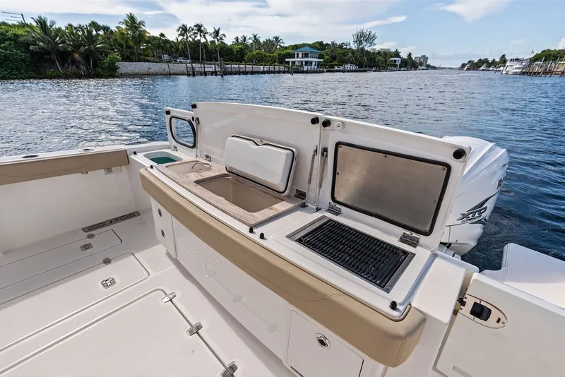 Slide: The Image of 2020 Pursuit S 408 Sport boat with outdoor kitchen and scenic water view. - 18