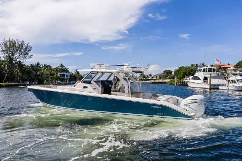 Slide: The Image of 2020 Pursuit S 408 Sport boat cruising on a sunny day in a marina. - 9