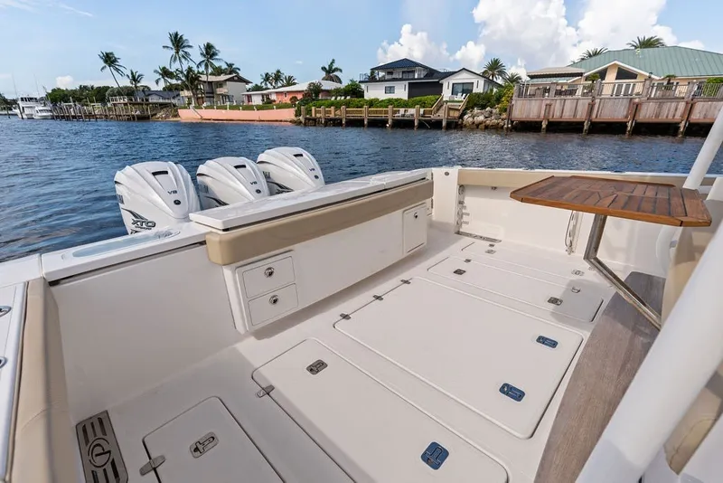 Slide: The Image of 2020 Pursuit S 408 Sport boat deck with triple outboard engines, dockside view. - 16