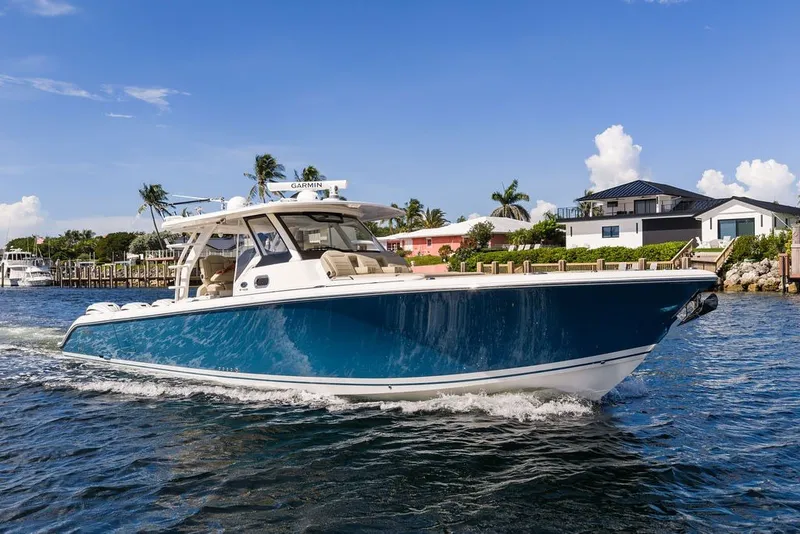 Slide: The Image of 2020 Pursuit S 408 Sport boat cruising on a sunny day near waterfront homes. - 3
