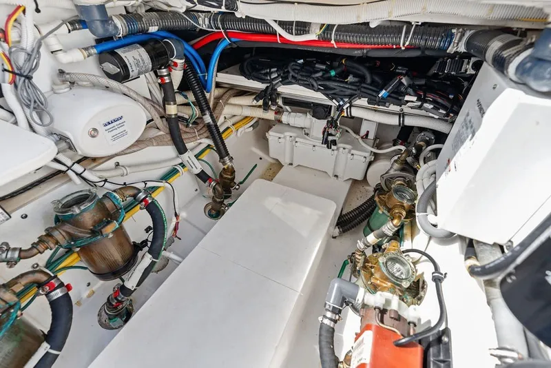 Slide: The Image of Engine room of 2020 Pursuit S 408 Sport boat, showcasing complex wiring and plumbing systems. - 49