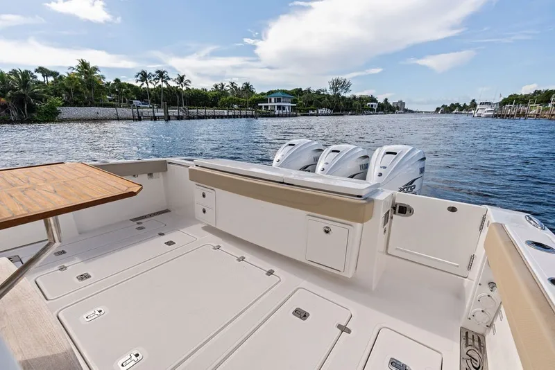 Slide: The Image of 2020 Pursuit S 408 Sport boat deck with triple Yamaha engines, dockside view. - 17